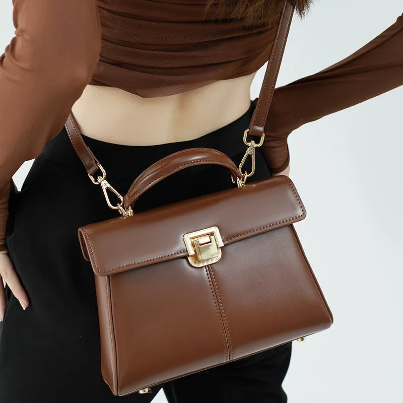 Black genuine leather women's shoulder bag with Vachette clasp closure and adjustable strap