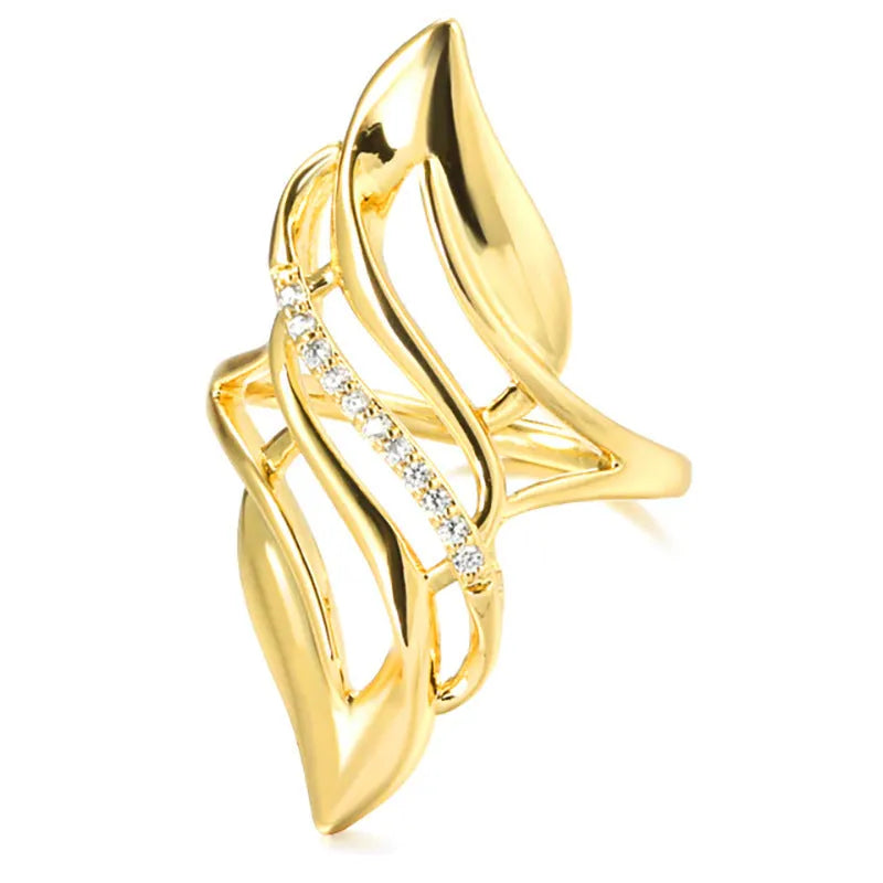 Gold tone women's ring with an exaggerated curved design on a model's finger.