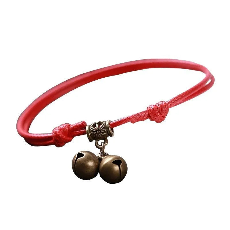 Adjustable black nylon dog collar with a brass bell for a small pet.
