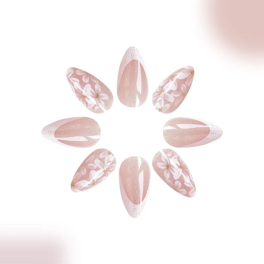 Short almond shaped artificial fingernails with French tips and glitter powder flower decorations, colour C625.