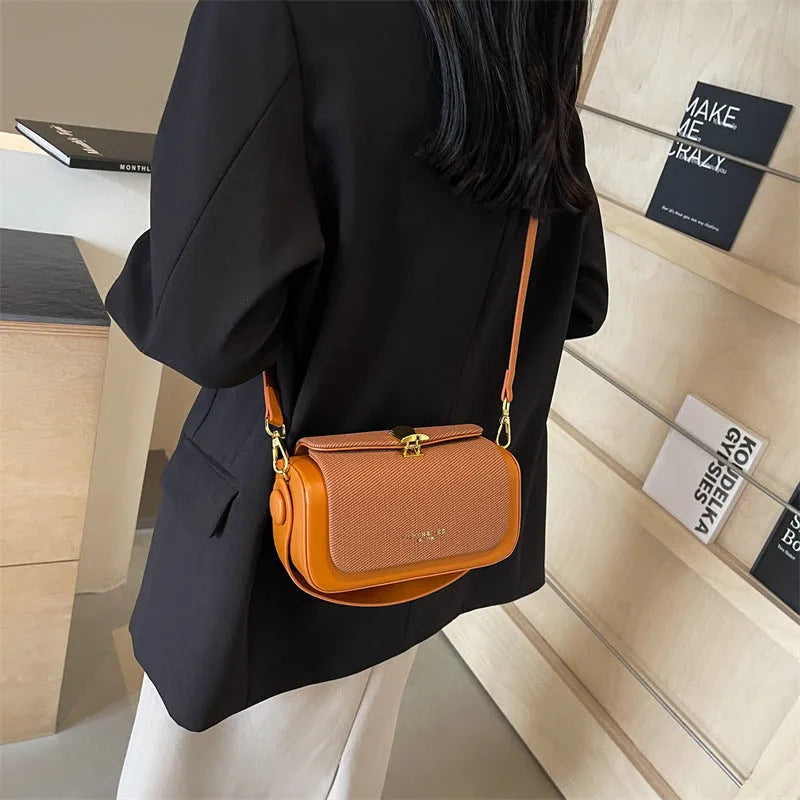 Women's black PU leather crossbody messenger bag with contrast stitching and lock detail