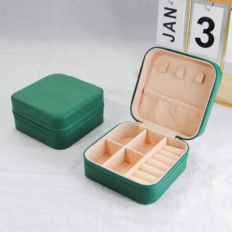 Small leather jewellery box in cross pattern, 10cm size, for earrings and rings, on a flat surface.