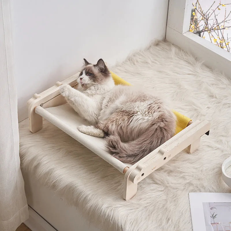 Solid wood cat bed with a removable plaid cushion on a wooden frame.