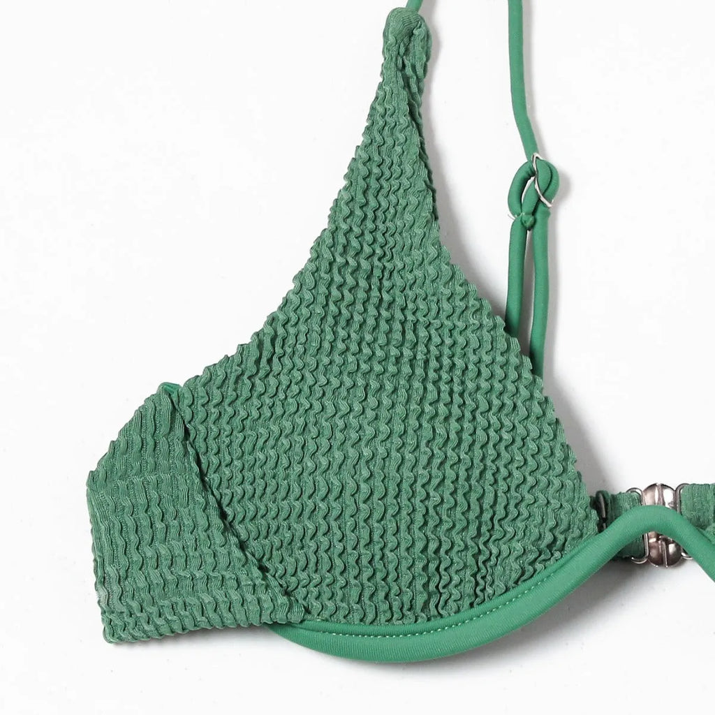 Women's solid green bikini suit with ruffle detailing and split-front design on mannequin