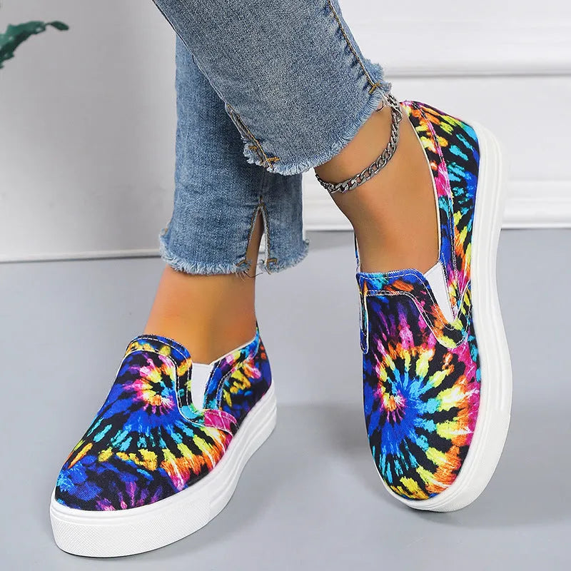 Women's low-top canvas trainers in blue, green, black and colourful designs on a flat rubber sole.