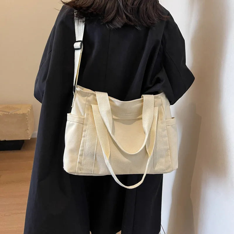 Large capacity polyester canvas shoulder tote bag in a solid colour, showing outer sandwich pocket.