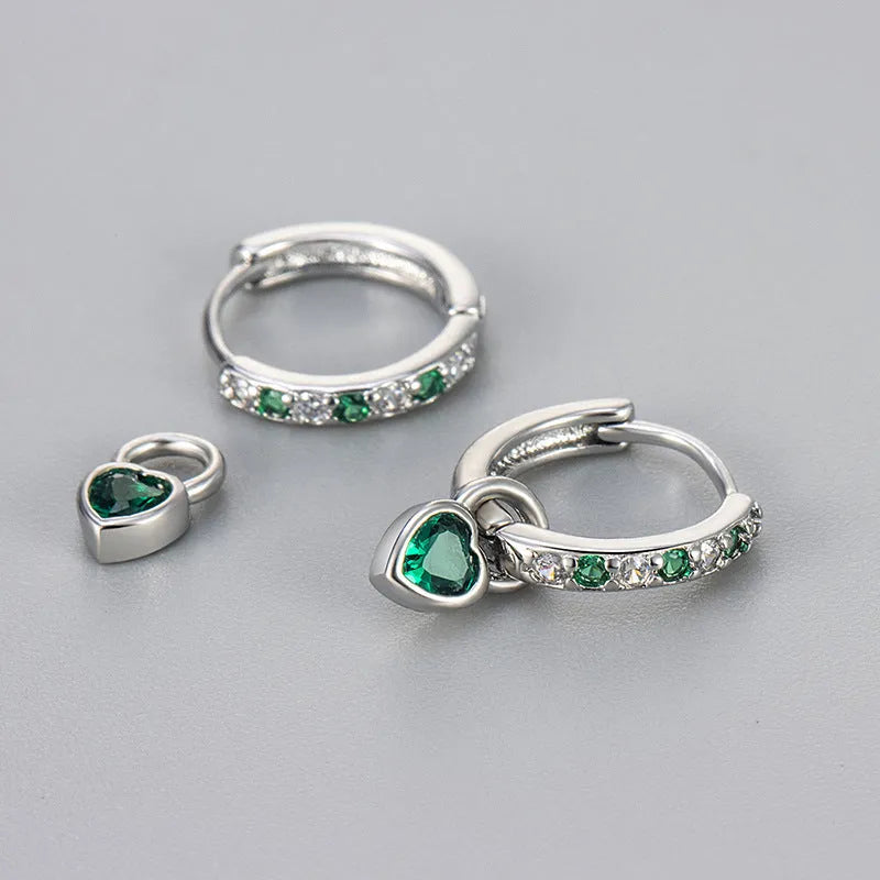 Gold colour heart-shaped clip earring with a central blue zircon stone on a white background.