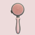 Green two-sided cat brush with retractable slicker and silicone massage pins on plastic handle