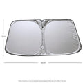 Titanium silver aluminium foil car windscreen sunshade unfolded on a dashboard.