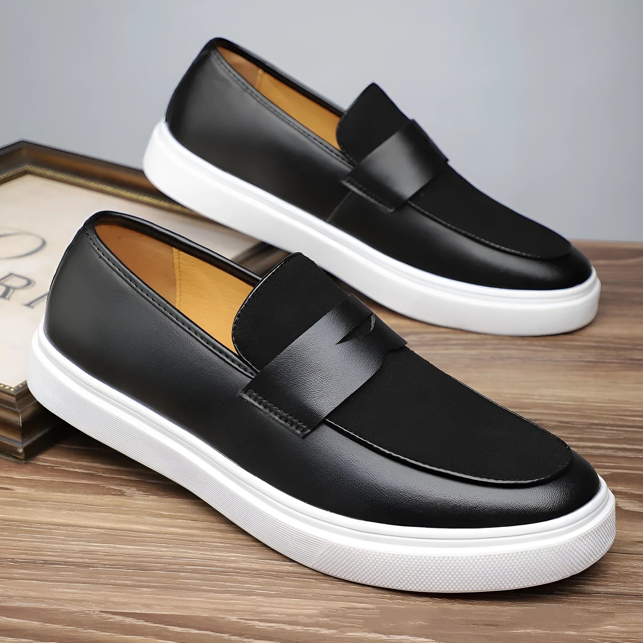 Men's black casual slip-on loafers with a tassel detail on the upper.