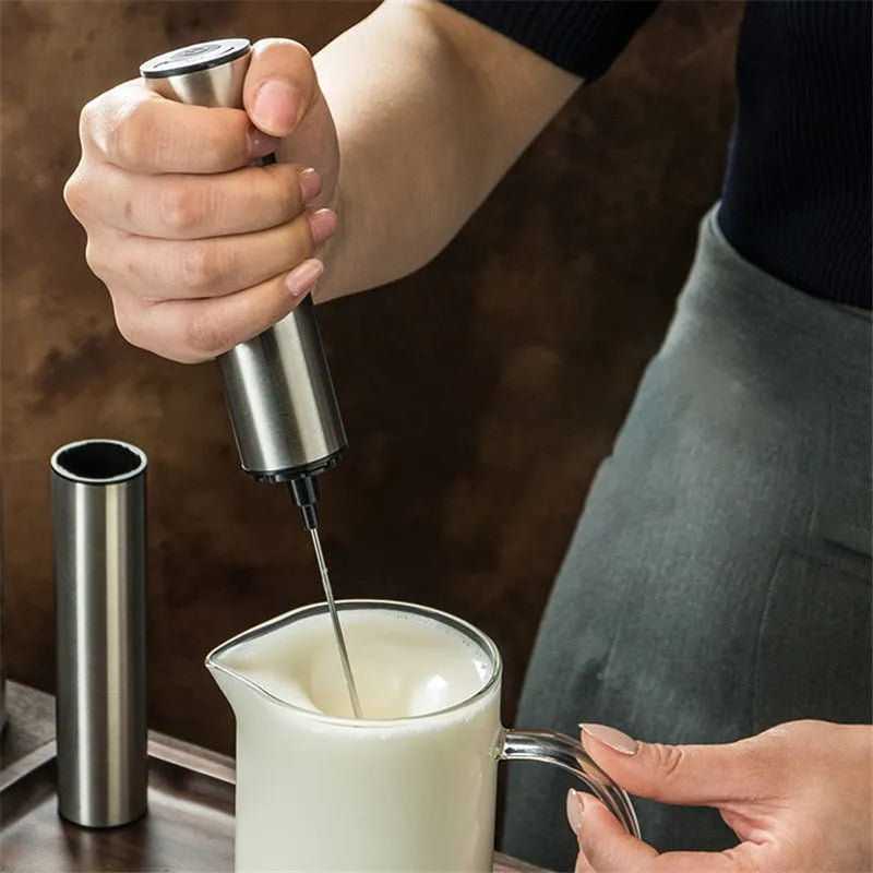Silver handheld electric milk frother with double teat stainless steel whisk head on white background