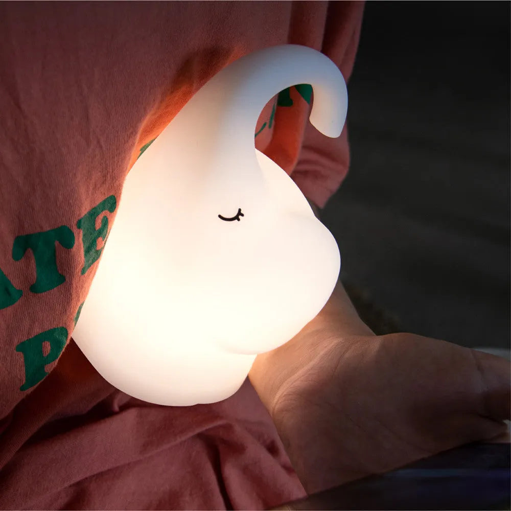 DOMI Elephant style silicone and plastic LED night light with warm white glow on a bedside table.