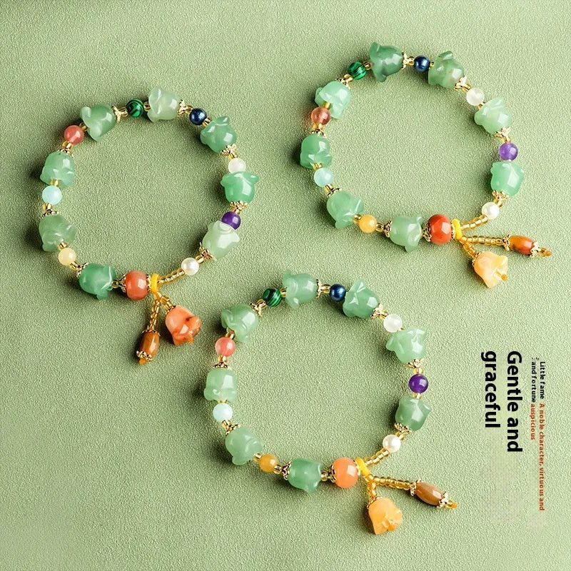 Natural Jinsi Jade bracelet with carved orchid beads on a wrist.