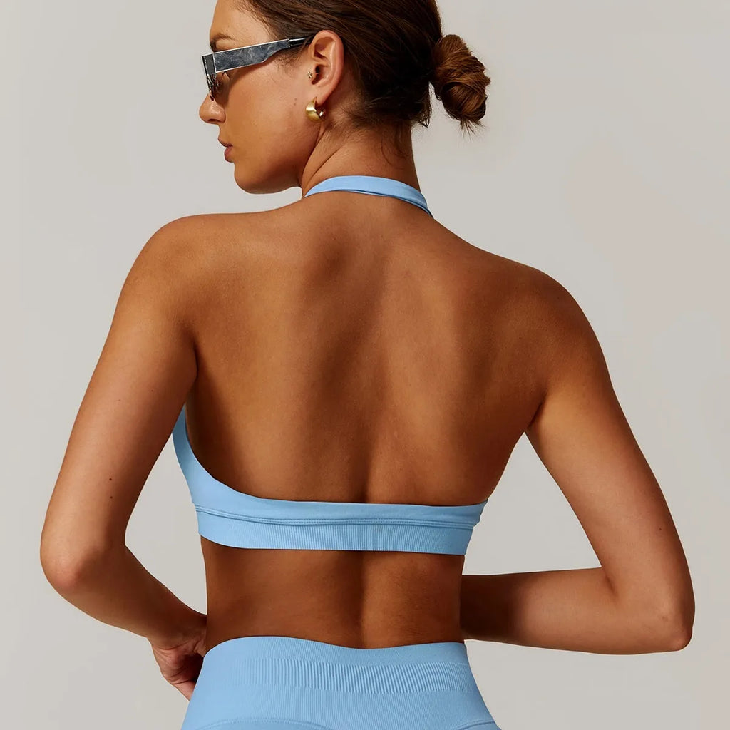 Women's black halter-style sports bra with removable pads for yoga and workout.
