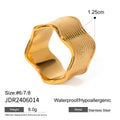 Silver and gold-tone stainless steel ring with a wide geometric wave design on a flat surface.