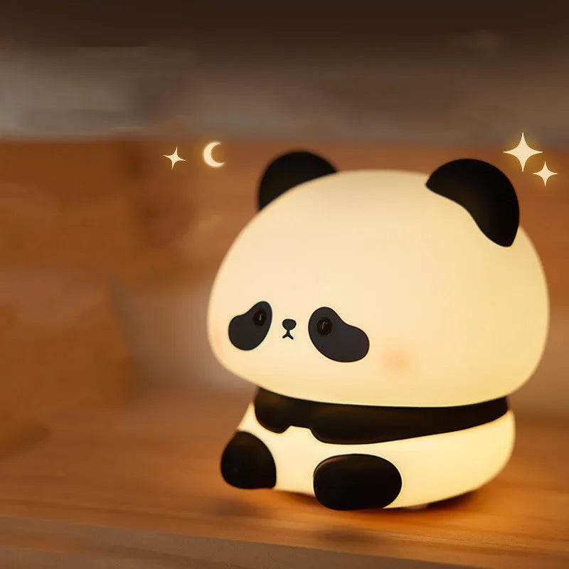 Cartoon panda rechargeable night light with soft silicone body on a wooden table