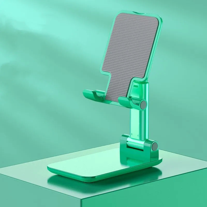 White folding telescopic mobile phone bracket holding a smartphone on a desktop.