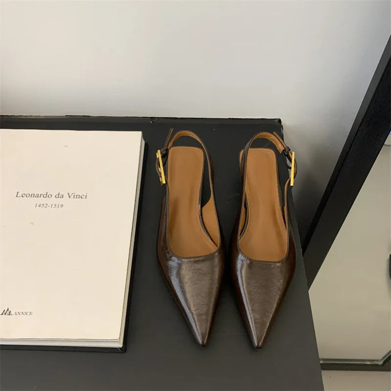Women's black leather pointed-toe shoes with a thin low heel and an ankle strap.