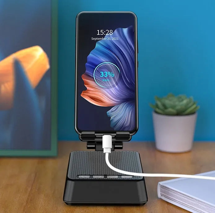 Black mobile phone smart broadcaster stand with Bluetooth speaker and HD mic on a desk