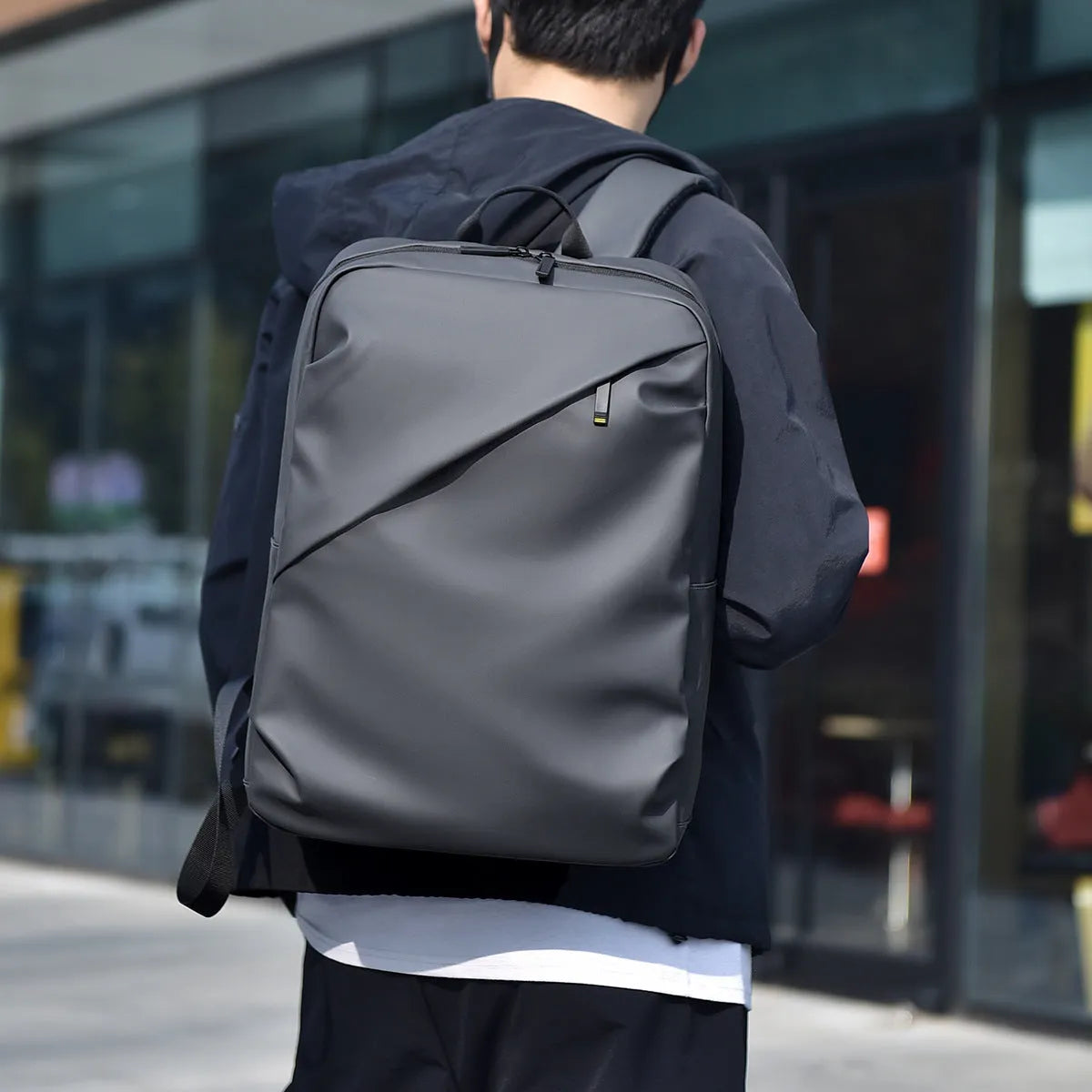 Men's waterproof backpack in black, blue or grey colour with PU leather construction and sewing thread detailing
