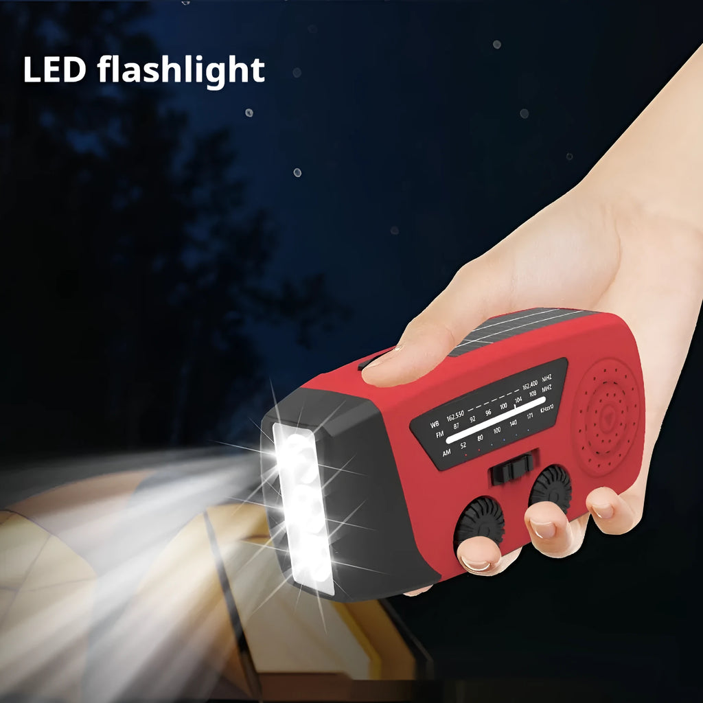 Red rechargeable hand-held emergency radio with integrated torch and wrist strap.