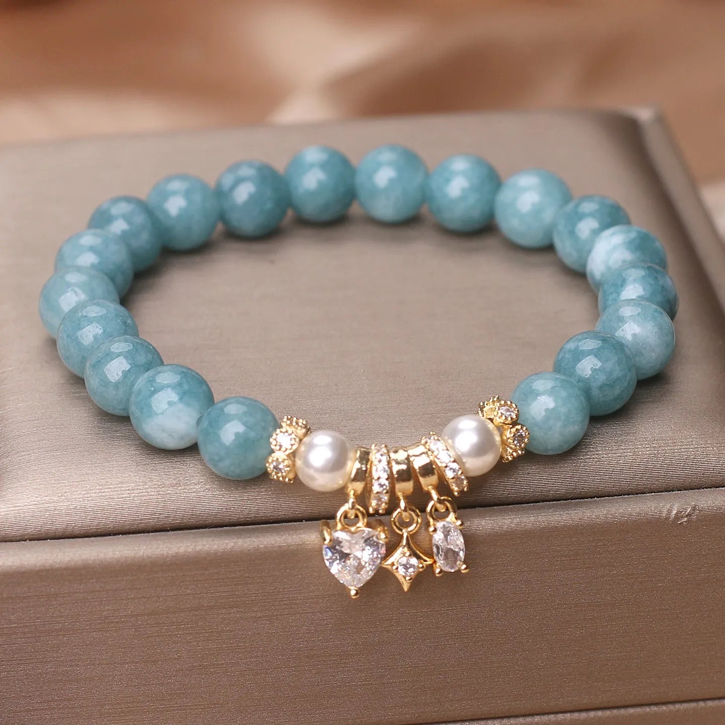 Blue water jade bracelet with heart-shaped zircon pendant and agate beads on display