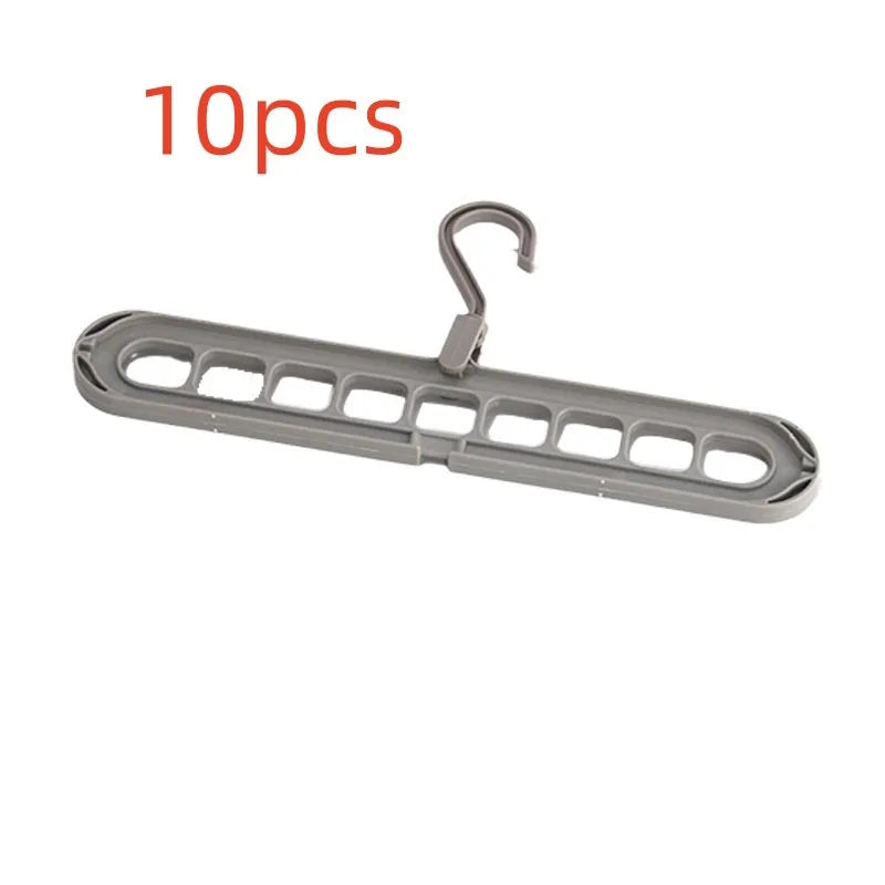 Green plastic nine-hole multifunctional clothes hanger for trousers on a white background.