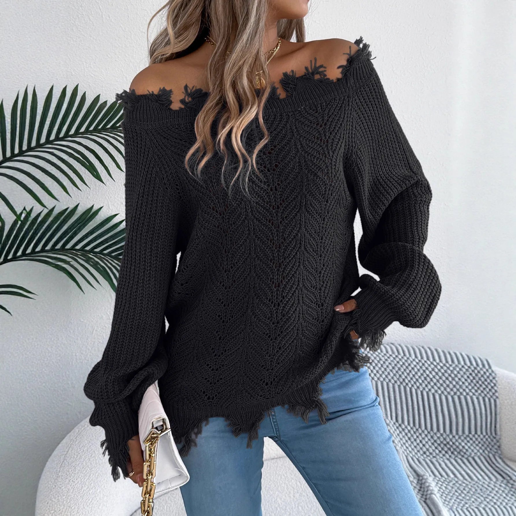 White cut-off-shoulder pullover sweater with hollow-out long sleeves on a mannequin.