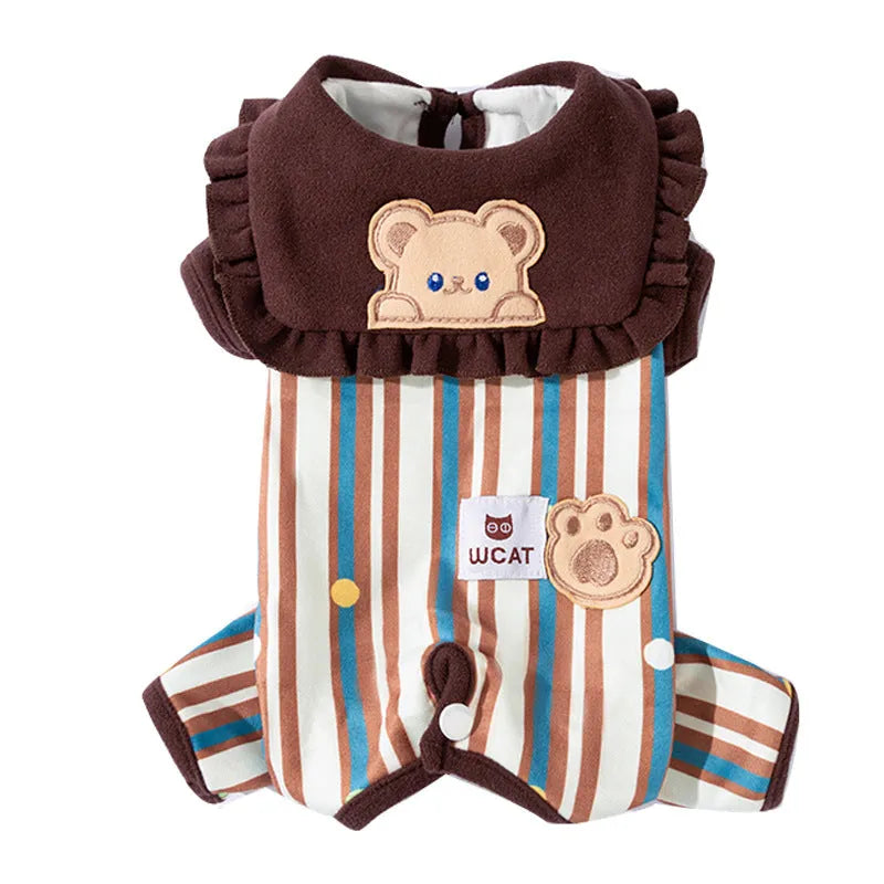 Small brown dog wearing a blue and brown striped onesie with ruffled collar and bear patch