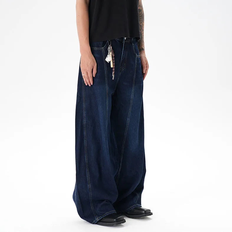 Dark blue washed distressed wide leg machete jeans on a model, showing the denim fabric and relaxed fit.