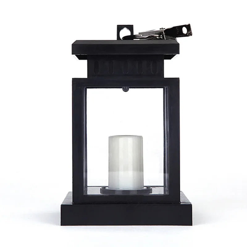 Solar LED candle light with black plastic shade, monocrystalline panel, and warm white illumination on garden path
