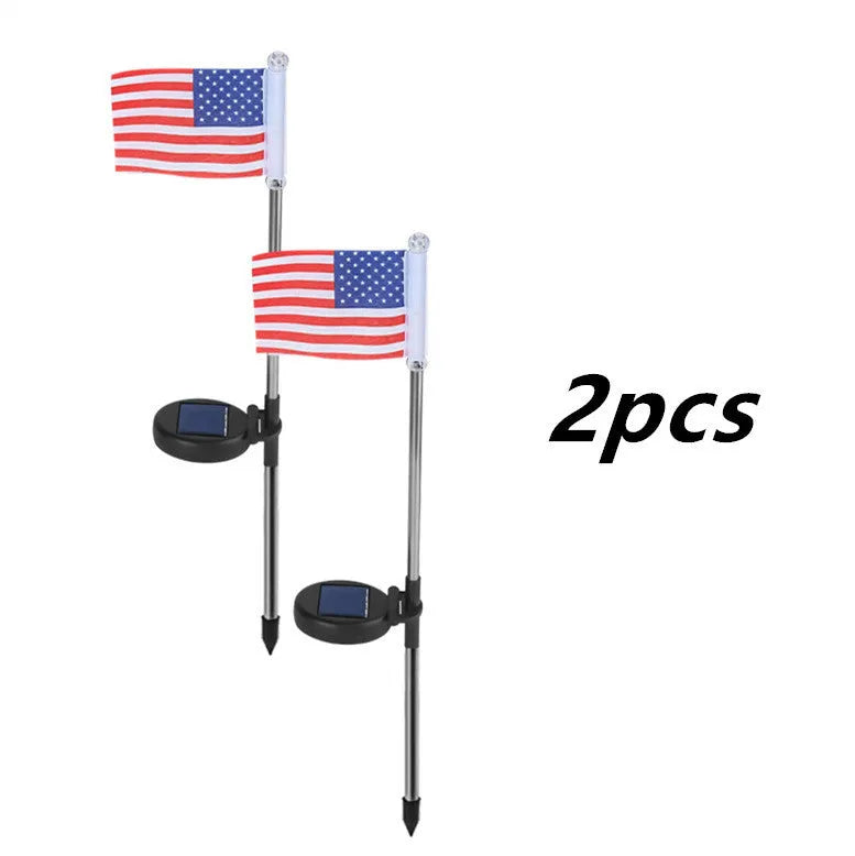 Solar-powered stainless steel garden flag light showing American flag design with white LEDs illuminated.