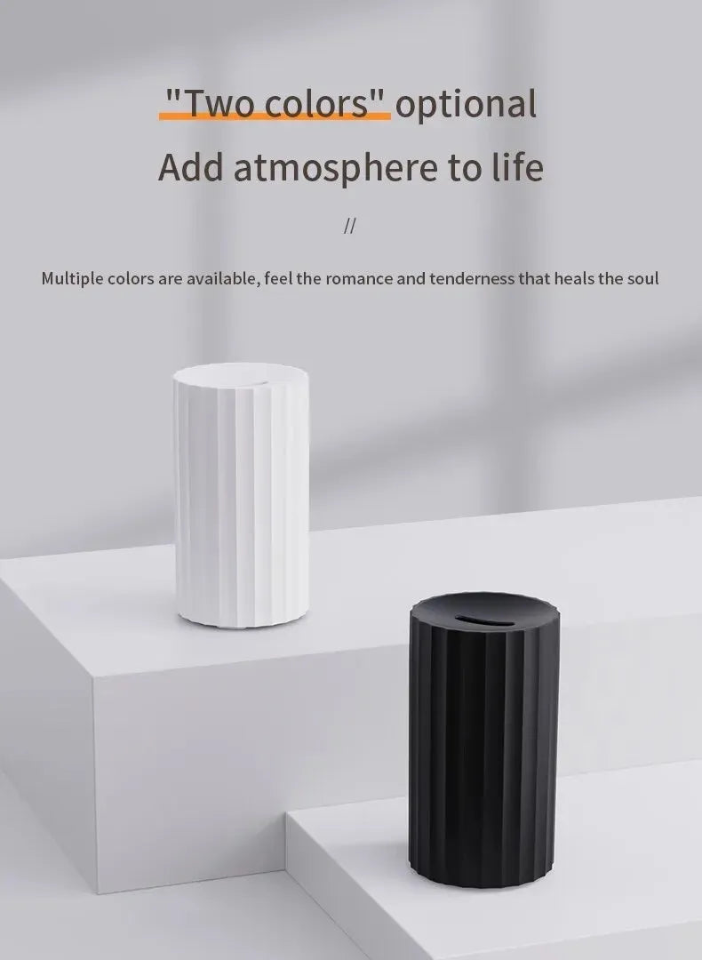 Black and white flame effect essential oil diffuser and air humidifier with coloured LED lights on a wooden table.