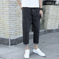 Men's black cotton straight-leg jeans with loose harem fit on adult male model