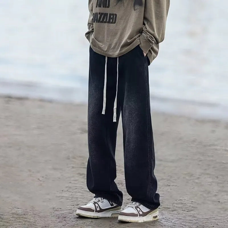 Men's loose fit straight-leg jeans in black or blue with drawstring waist closure