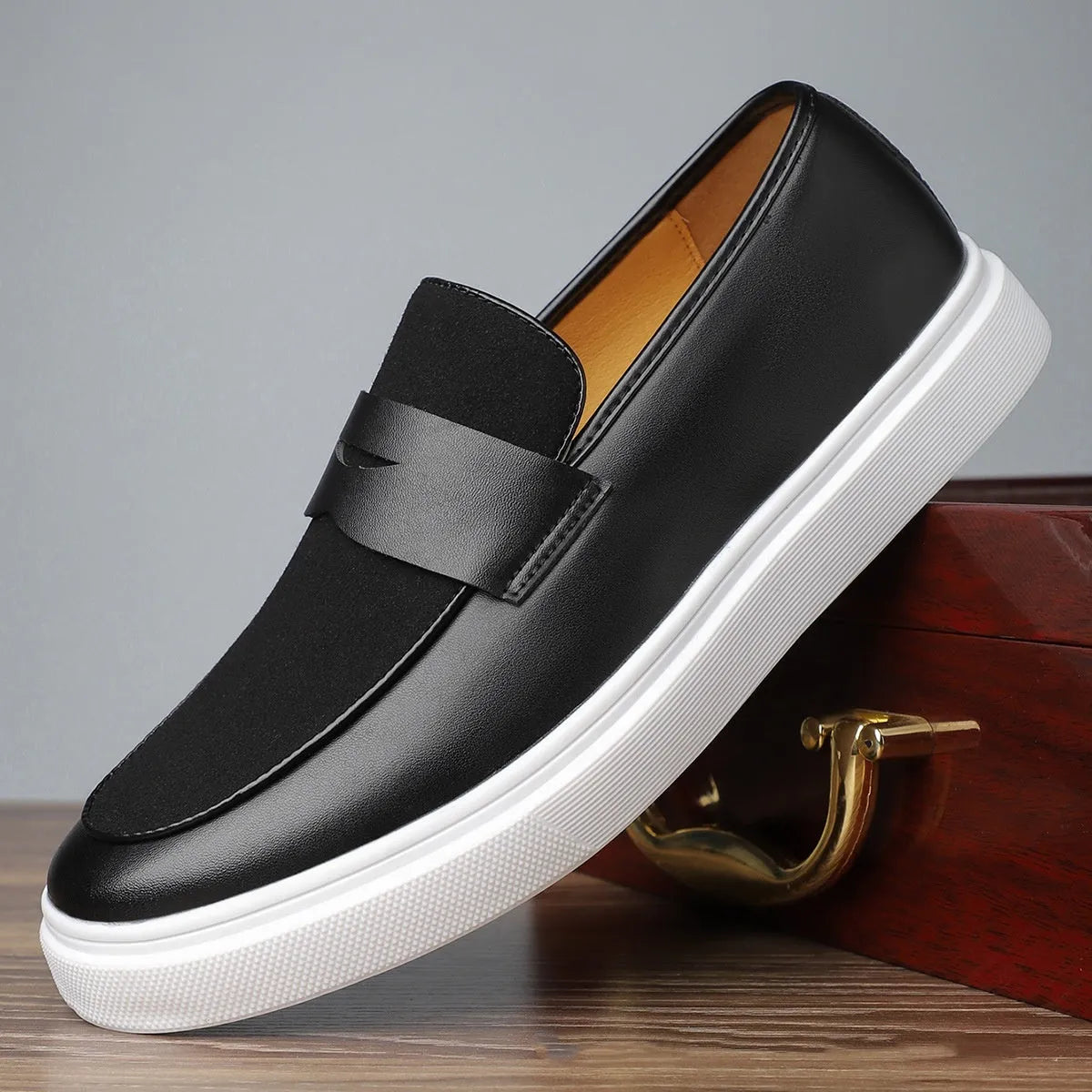 Men's black casual slip-on loafers with a tassel detail on the upper.