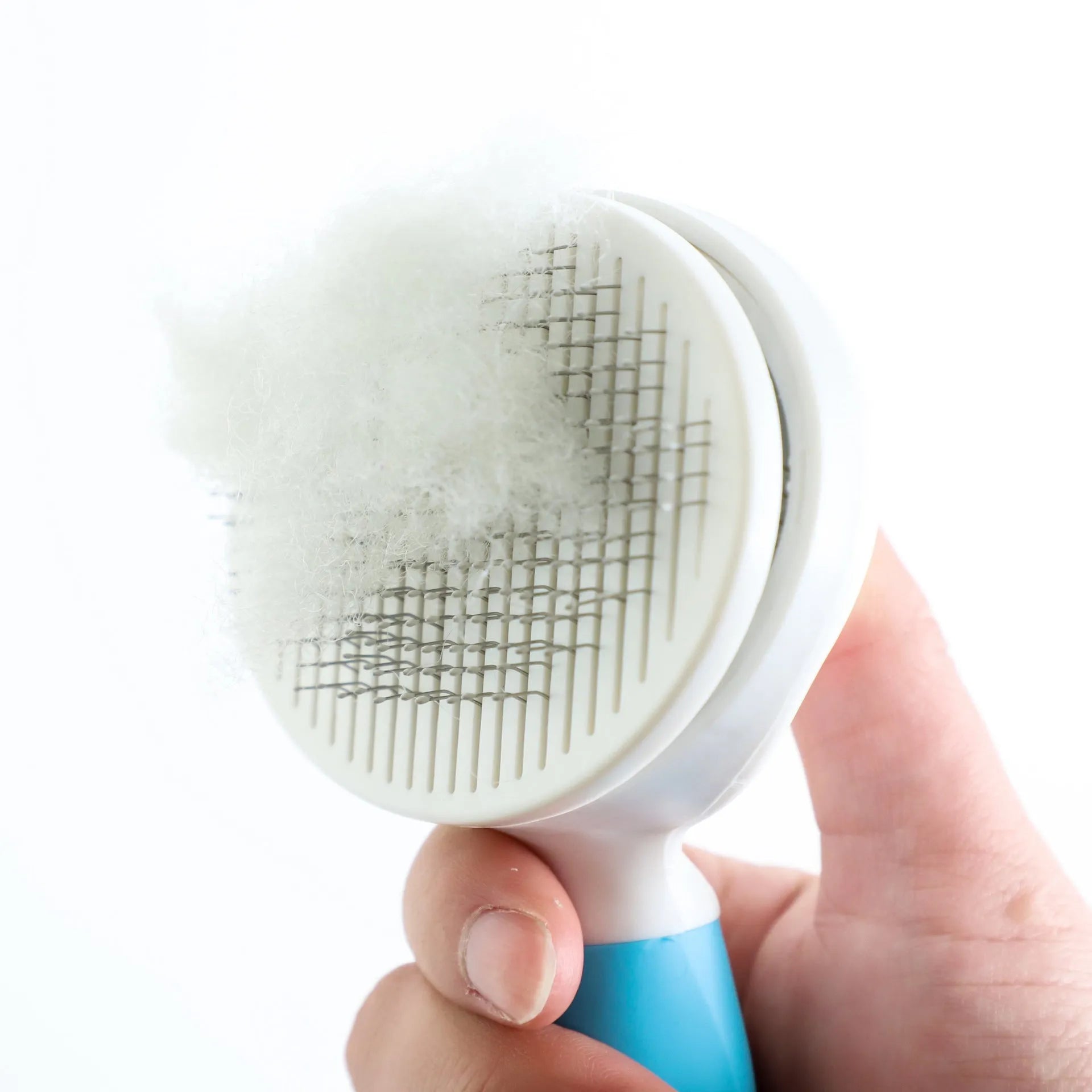 Blue automatic hair removal pet comb with TPR non-slip grip and button shaved design on white background