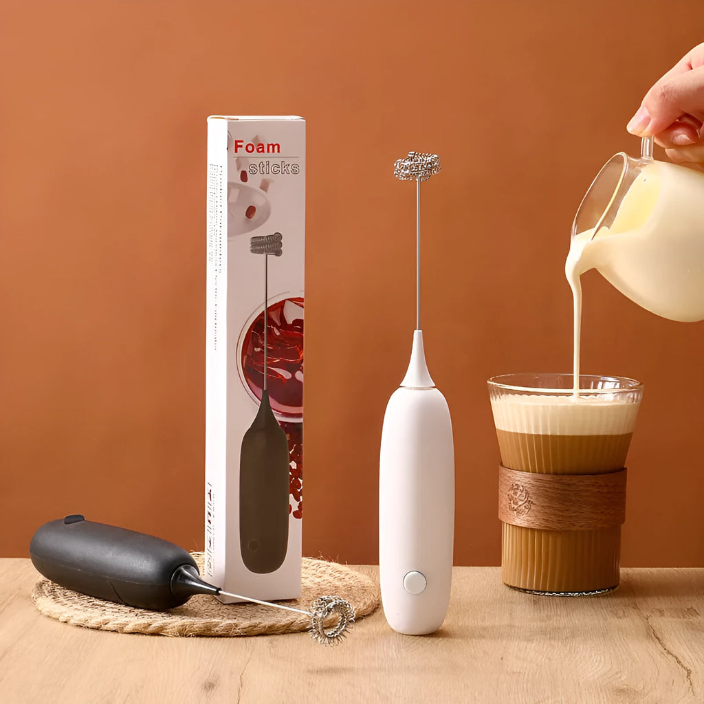 Black and white electric hand-held milk frother and blender for coffee beverages