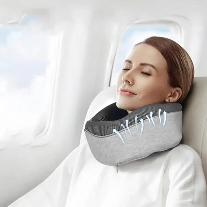 U-shaped memory foam travel neck pillow rolled up next to its carry bag, showing navy blue and grey colour options.
