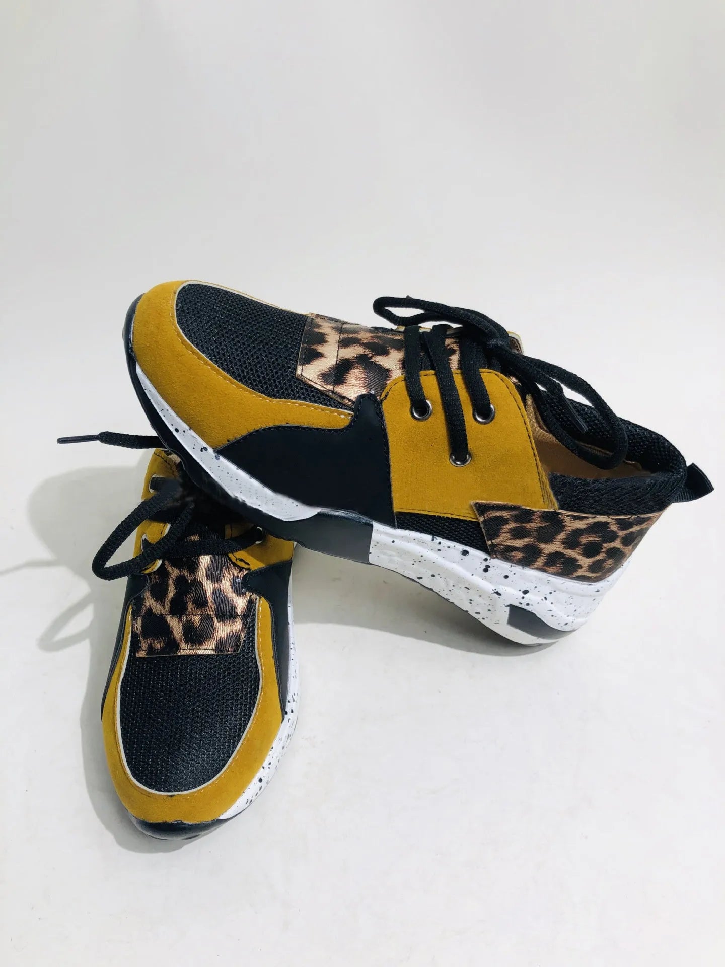 Women's casual suede sneakers with a wedge heel in black, leopard, pink, and snake pattern colours.