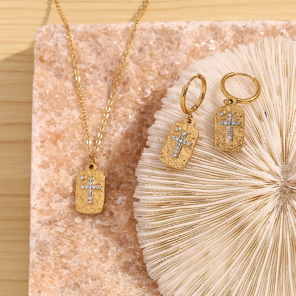 Gold micro inlay rhinestone cross hammer necklace on woman with quadrilateral geometric pendant on stainless steel chain