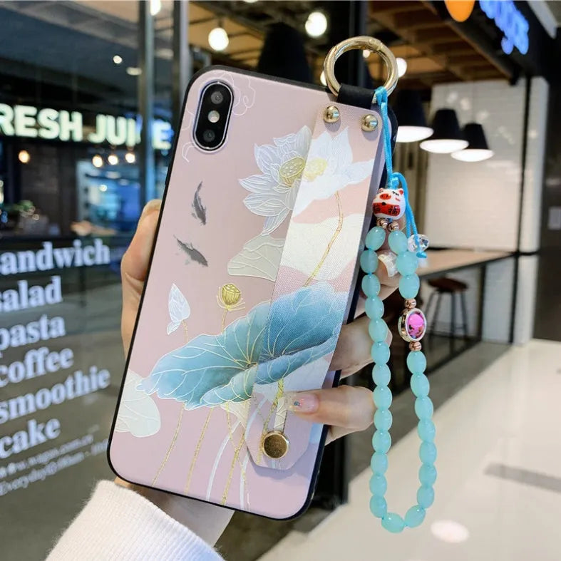 Rose flower design iPhone case with a white wrist strap attached, shown on an iPhone 11.