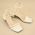 Beige women's chunky heel sandals with a square toe and ankle strap on a rubber sole.