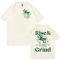 A loose-fit linen T-shirt with a Rise And Grind Green Coffee cartoon print, shown in one of ten available colours.