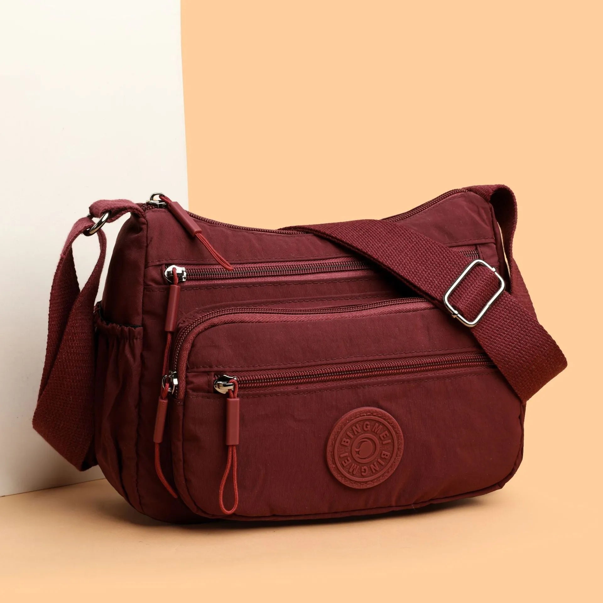 Grey water-repellent nylon crossbody bag showing outer pocket and internal organiser compartments.