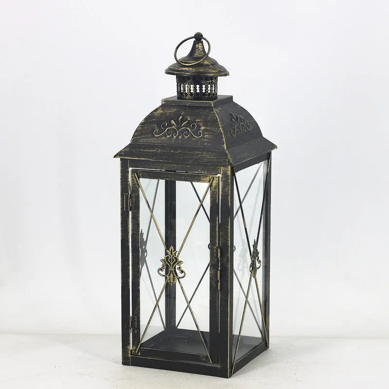 European wrought iron storm lantern with tempered glass in black or white gold finish, shown in small, medium, and large sizes.