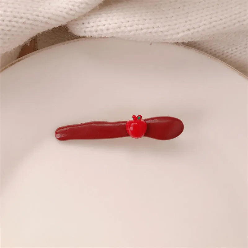 Red love heart-shaped plastic hair clip with retro dots and a willow leaf silhouette on a white background.