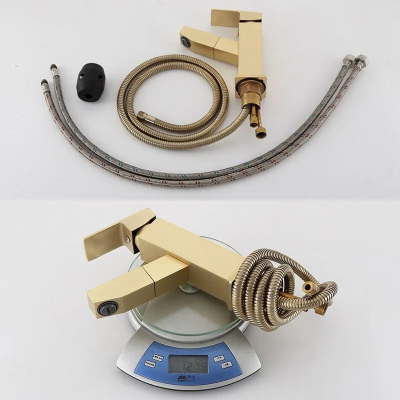 Square handle brushed gold pull faucet with brass construction on a sink.