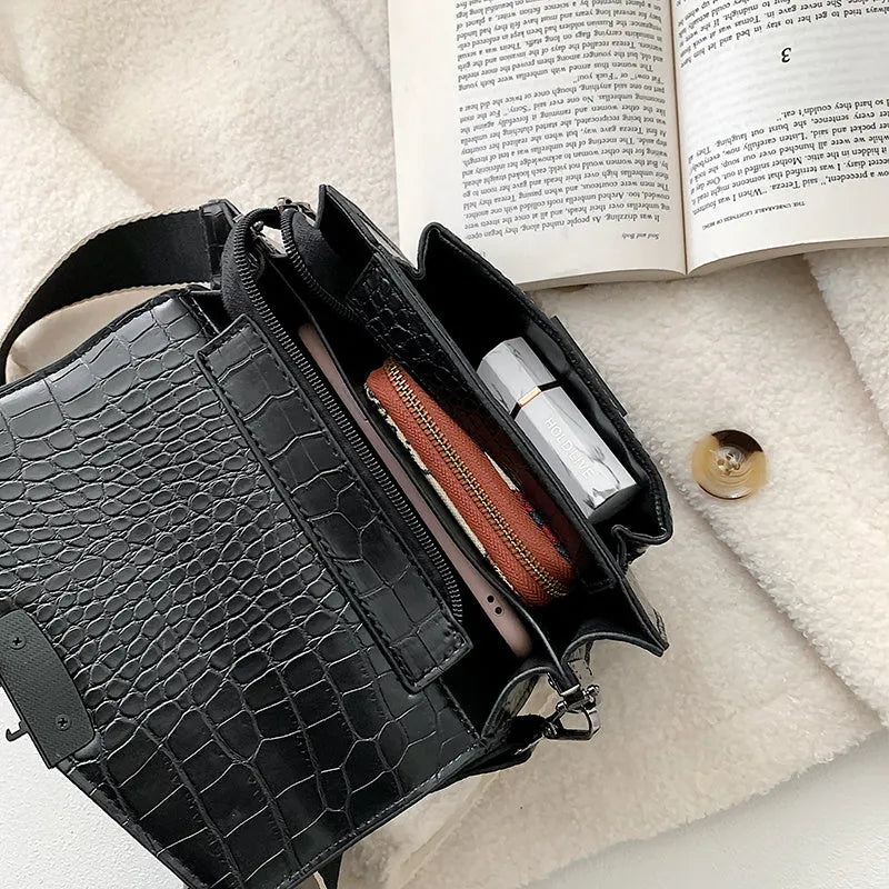 Vintage PU leather crossbody bag in black, shown with a mobile phone and wallet inside