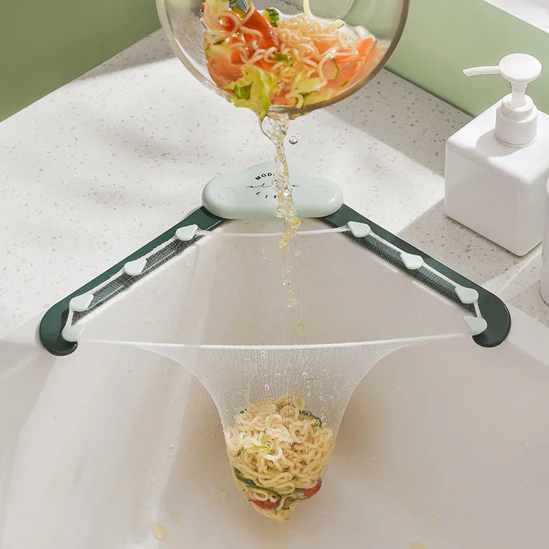 Grey triangular sink drain rack with a disposable filter mesh bag installed in a kitchen sink.